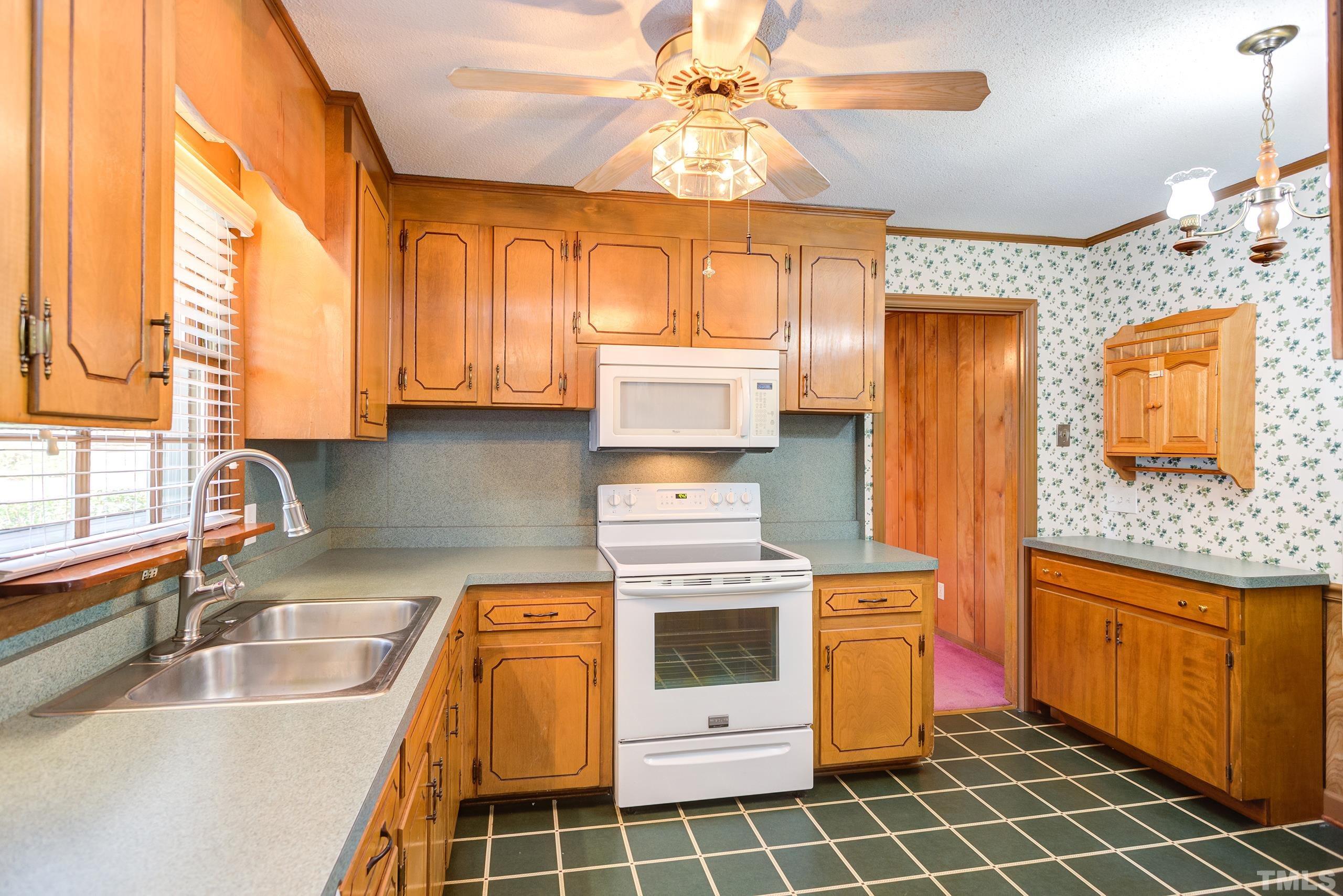 2312 Gresham Lake Road Raleigh, NC 27615 - Photo 3 of 46 a kitchen with stainless steel appliances granite countertop a stove a sink and a microwave