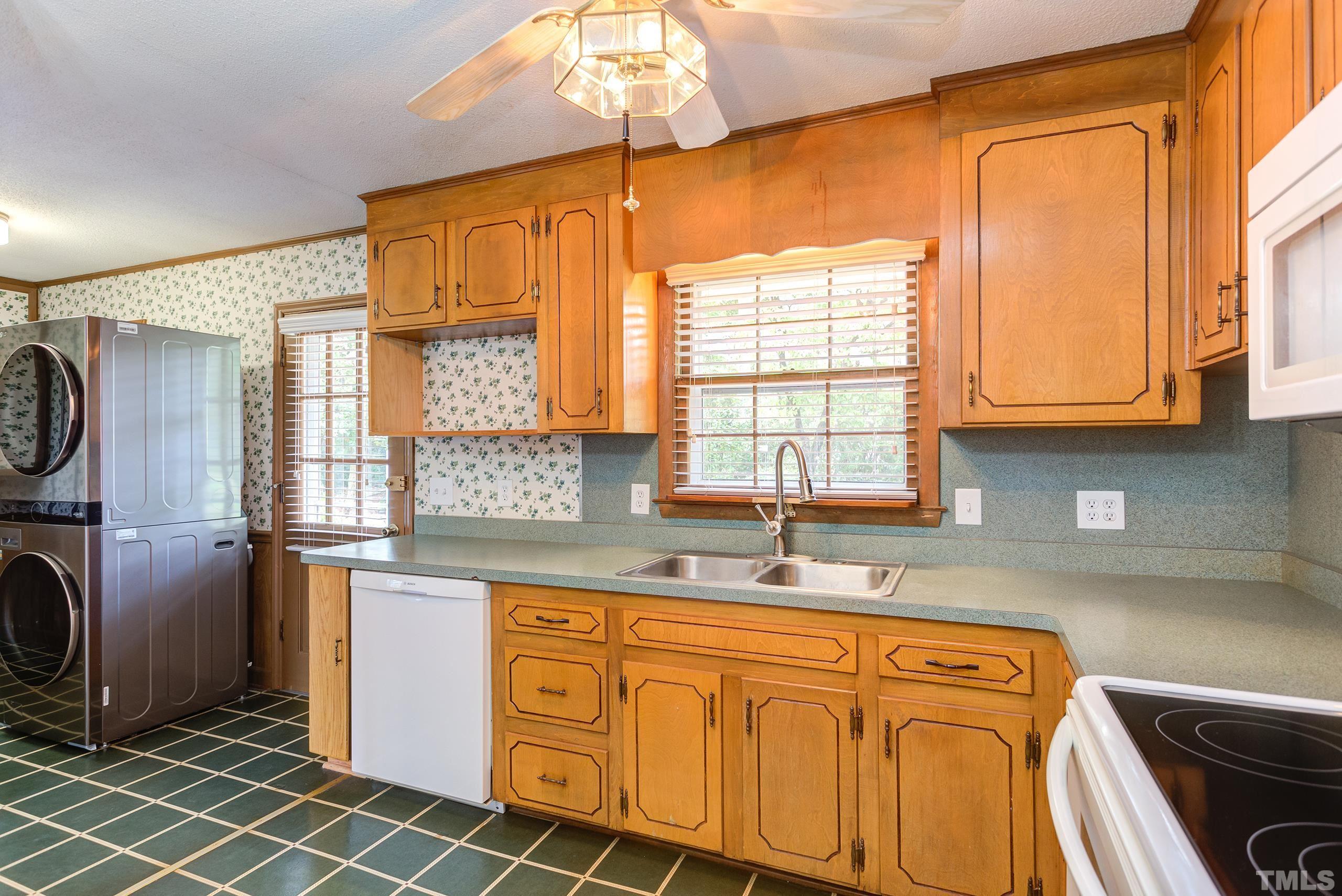 2312 Gresham Lake Road Raleigh, NC 27615 - Photo 4 of 46 a kitchen with stainless steel appliances a sink a stove a refrigerator cabinets and a window