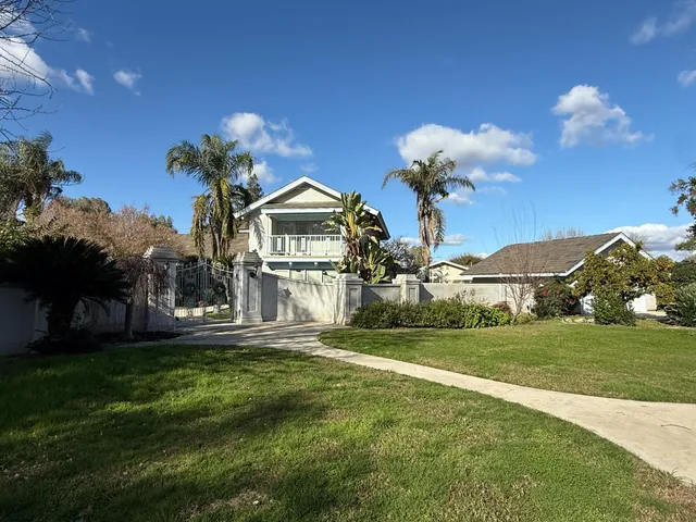 a front view of a house with a garden and yard