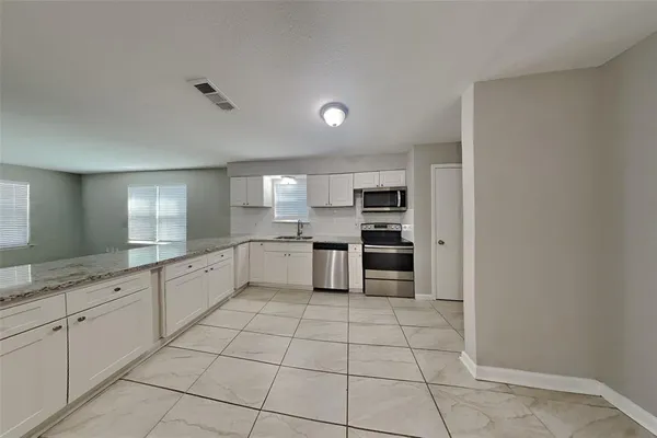 a large white kitchen with a sink and cabinets