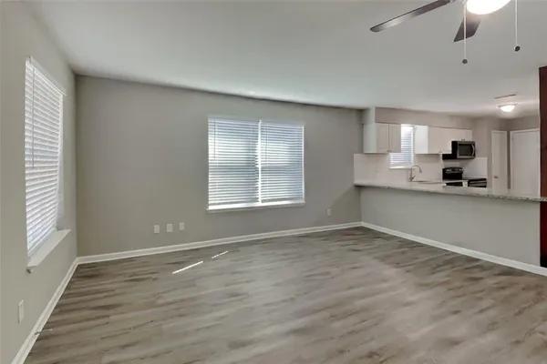 an empty room with wooden floor and windows