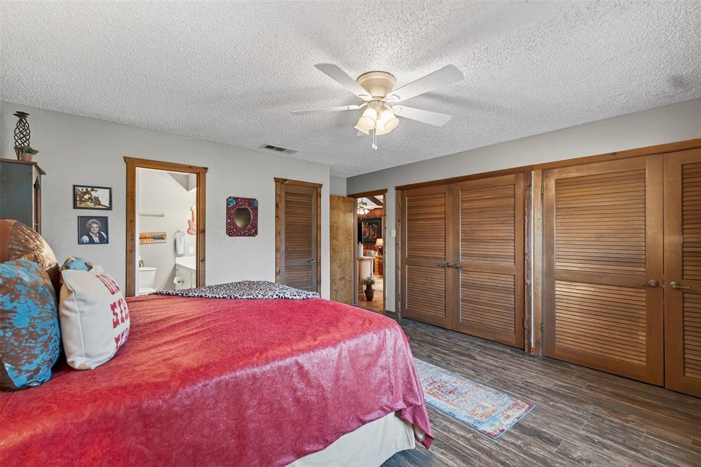 3030 Wager Road Flower Mound, TX 75028 - Photo 14 of 39 a spacious bedroom with a bed and a chandelier