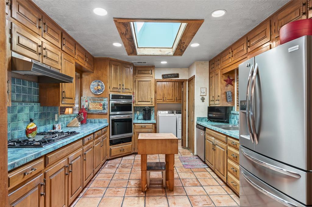 3030 Wager Road Flower Mound, TX 75028 - Photo 17 of 39 a large kitchen with stainless steel appliances kitchen island granite countertop a refrigerator and a stove