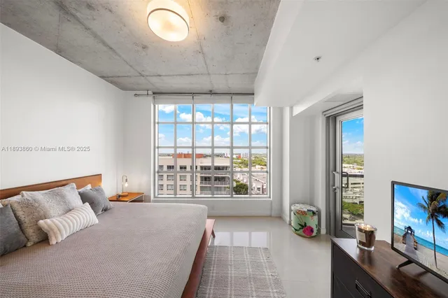 a bedroom with a large bed and a large window