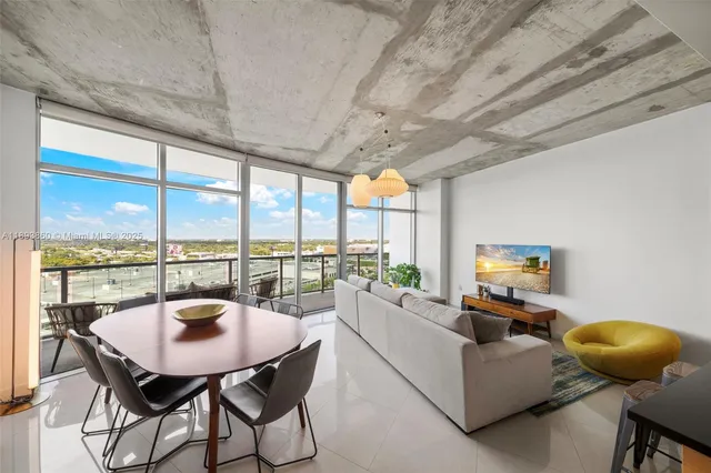 a living room with furniture and floor to ceiling windows