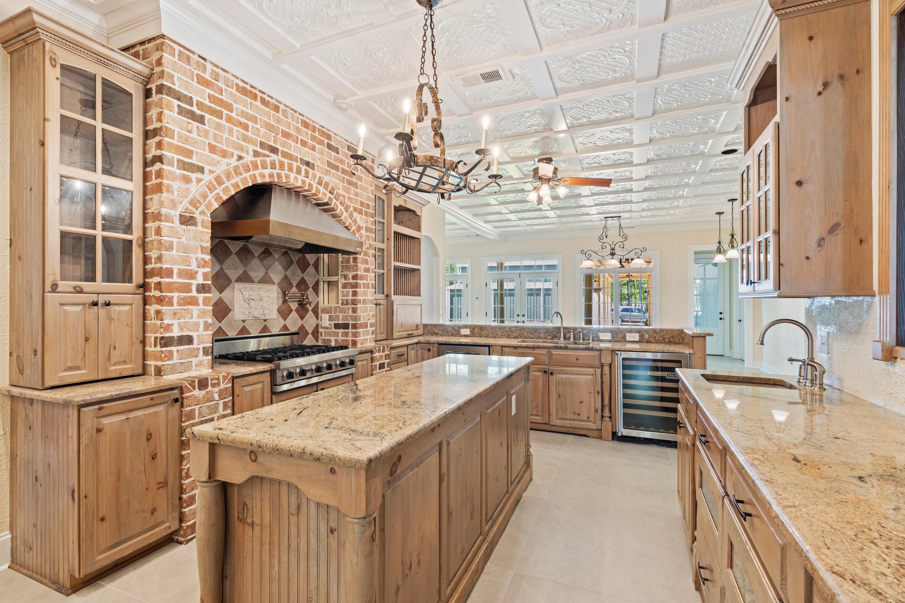 815 Dent Road Eads, TN 38028 - Photo 11 of 40 Kitchen featuring glass insert cabinets, light stone counters, a peninsula, beverage cooler, and an ornate ceiling