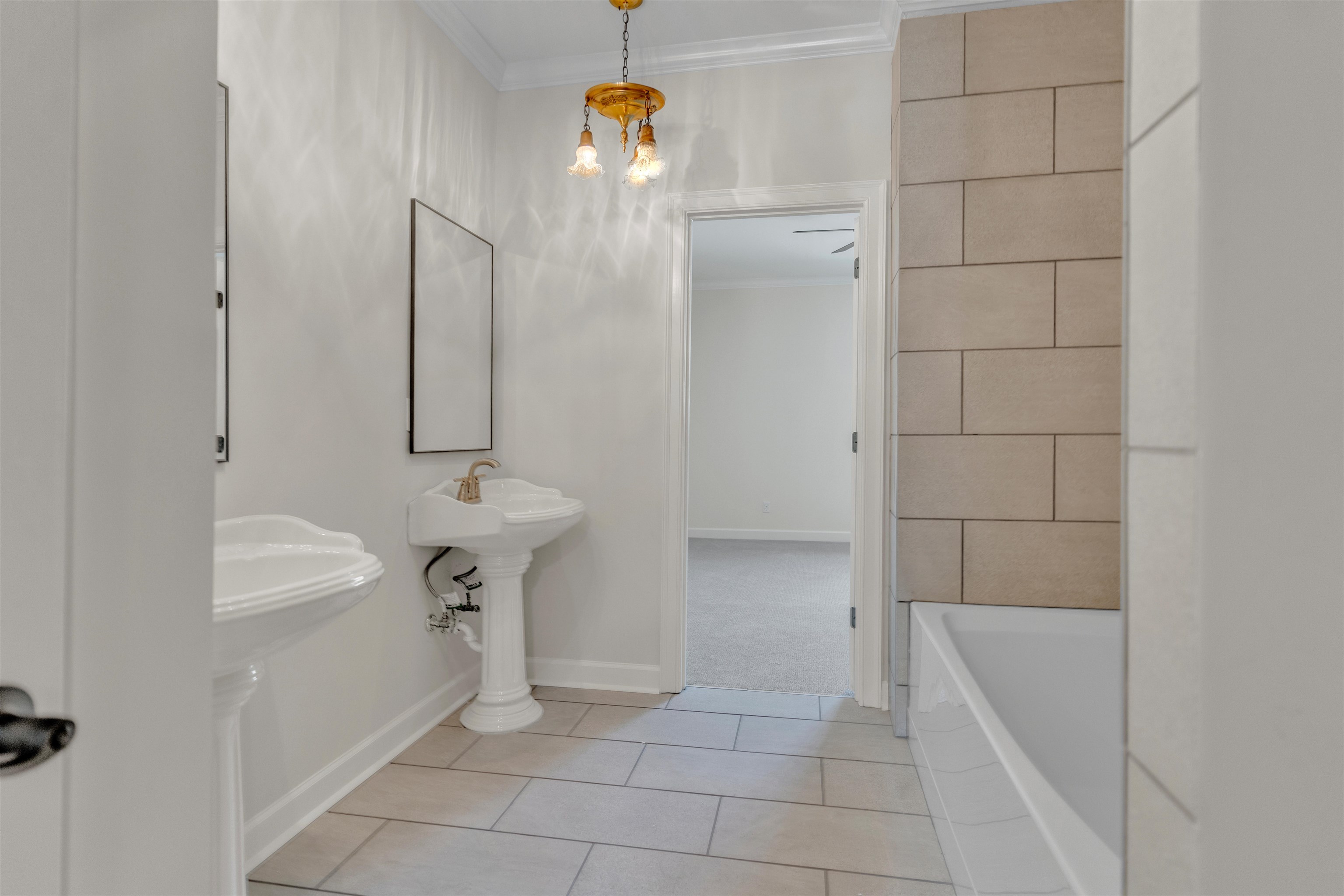 815 Dent Road Eads, TN 38028 - Photo 31 of 40 Bathroom featuring ornamental molding, a bathtub, light tile patterned floors, and a chandelier