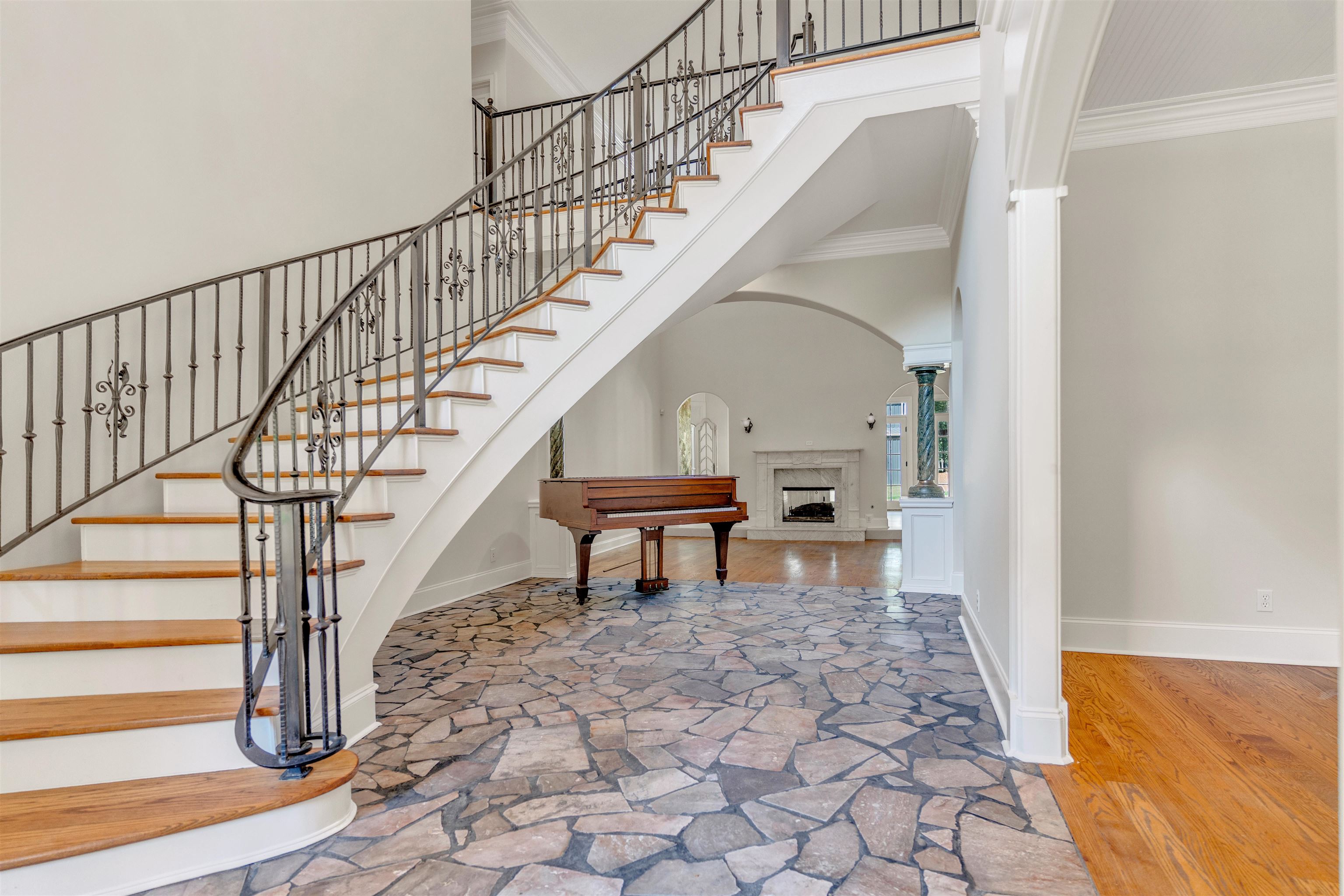 815 Dent Road Eads, TN 38028 - Photo 4 of 40 Foyer featuring a high ceiling, a fireplace with raised hearth, ornamental molding, wood finished floors, and stairway