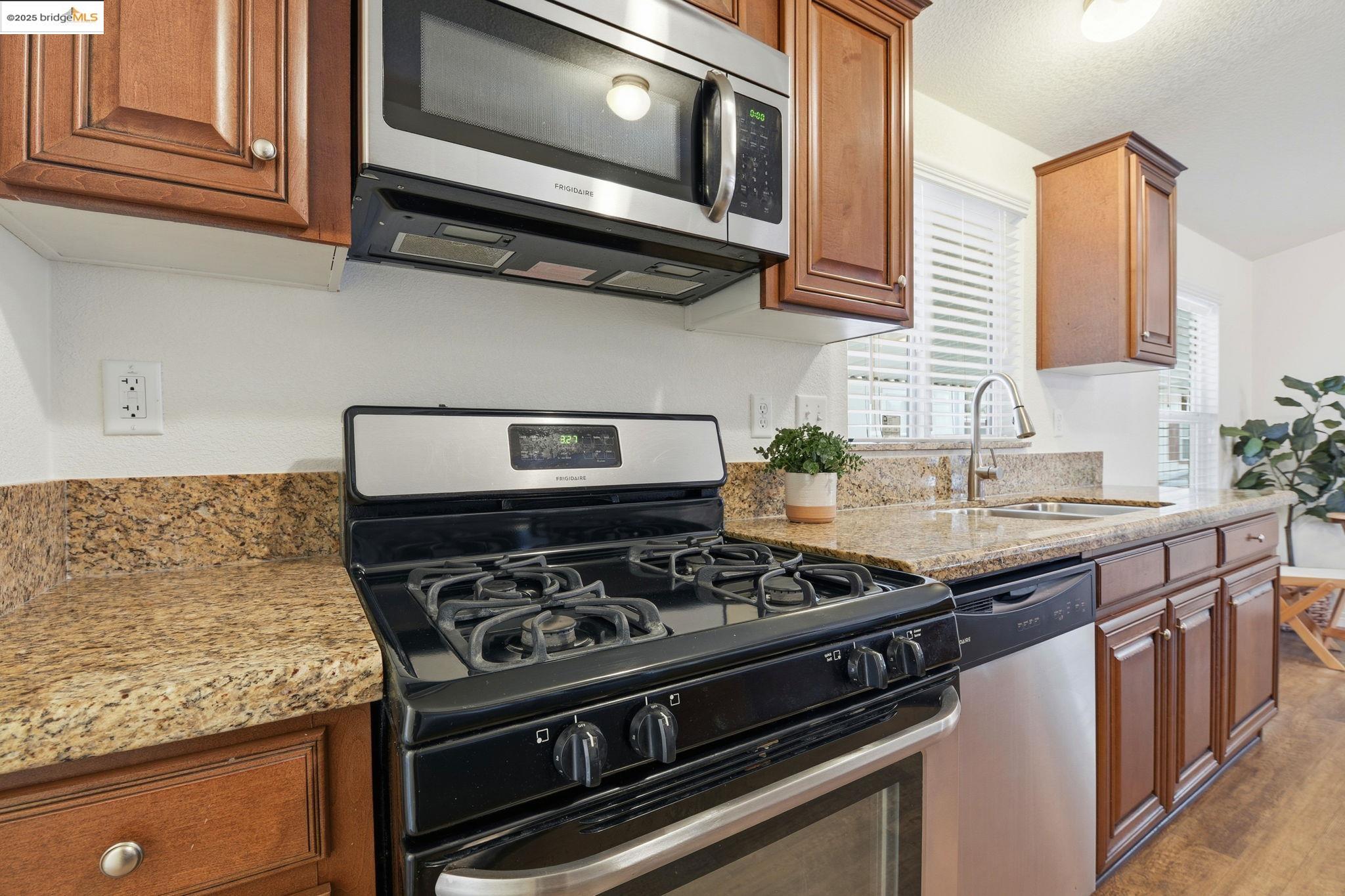 16711 Marsh Creek Road, Unit 111 Clayton, CA 94517 - Photo 14 of 34 a kitchen with stainless steel appliances granite countertop a stove and a microwave