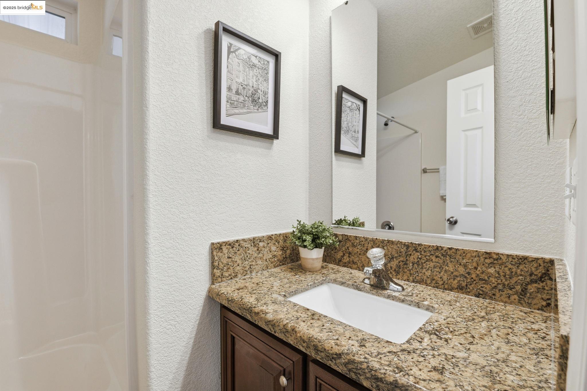 16711 Marsh Creek Road, Unit 111 Clayton, CA 94517 - Photo 27 of 34 a bathroom with a granite countertop sink and a mirror