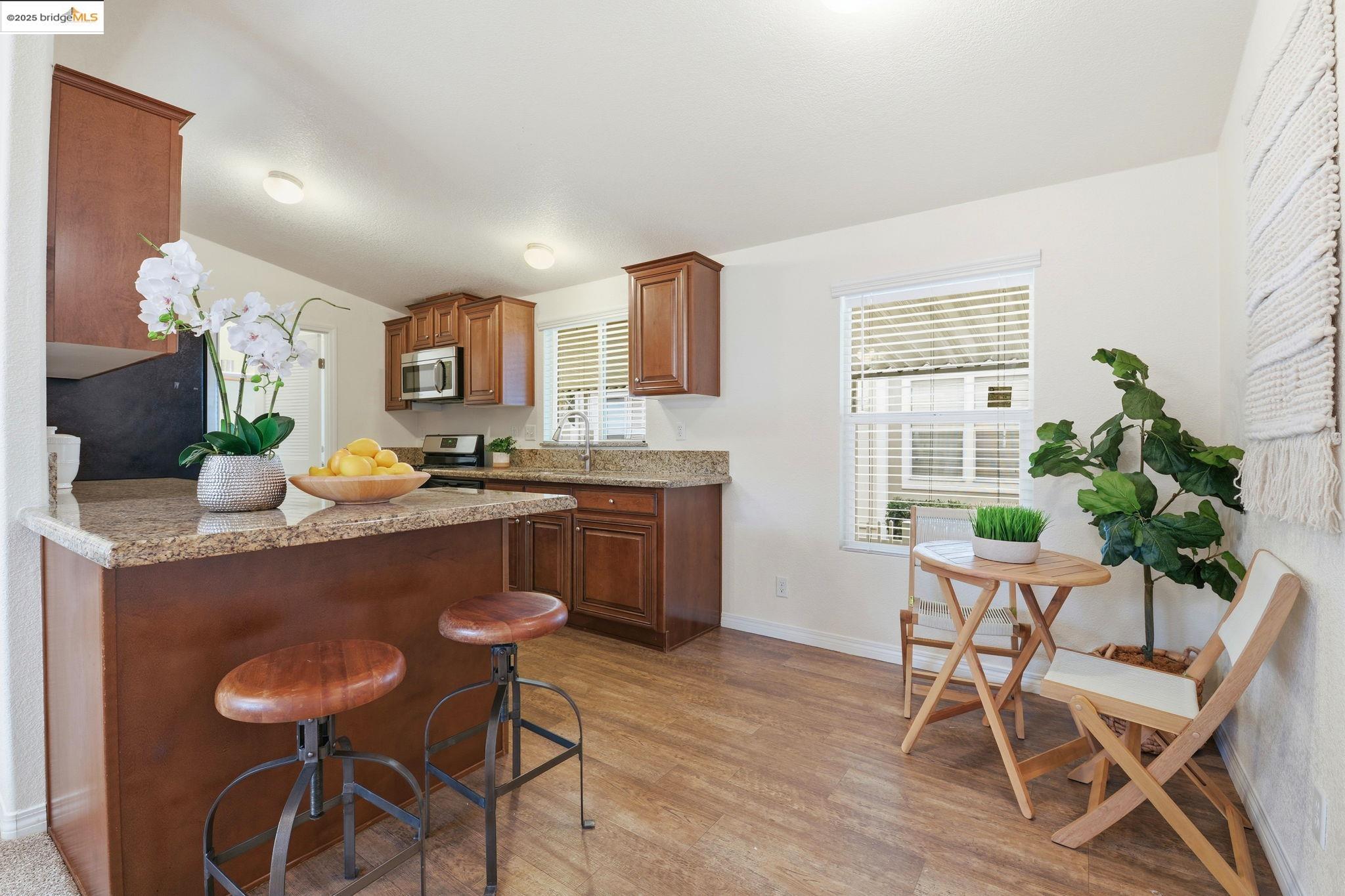 16711 Marsh Creek Road, Unit 111 Clayton, CA 94517 - Photo 3 of 34 a kitchen with granite countertop a table chairs stove and cabinets