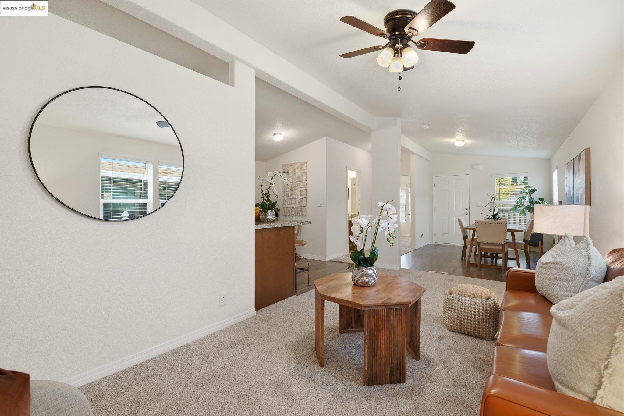 16711 Marsh Creek Road, Unit 111 Clayton, CA 94517 - Photo 10 of 34 a living room with furniture a mirror and a chandelier