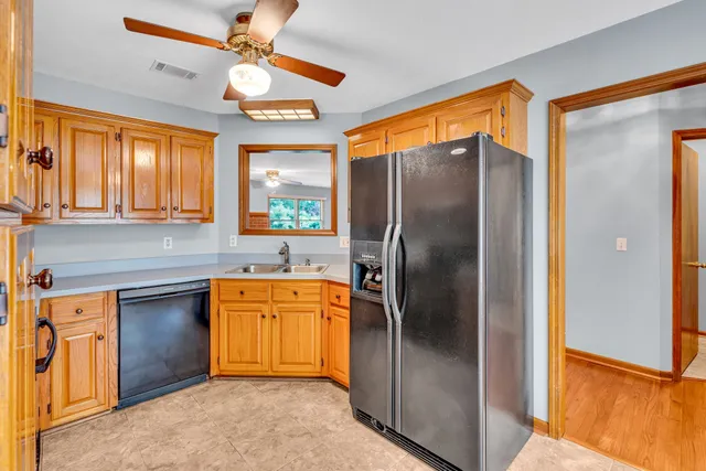 a kitchen with stainless steel appliances granite countertop a refrigerator a sink and dishwasher