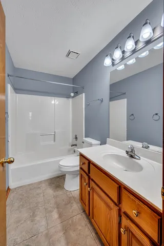 a bathroom with a sink a toilet and a large mirror