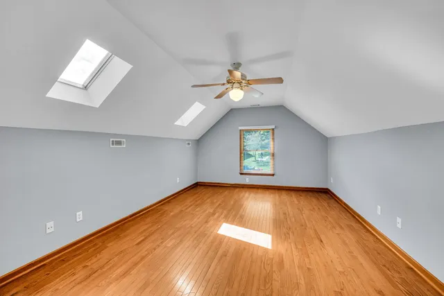 an empty room with a window and a ceiling fan