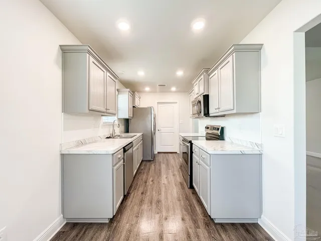 a kitchen with a sink stove cabinets and refrigerator