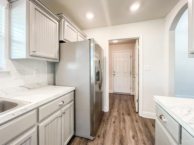 a kitchen with a sink a refrigerator and cabinets