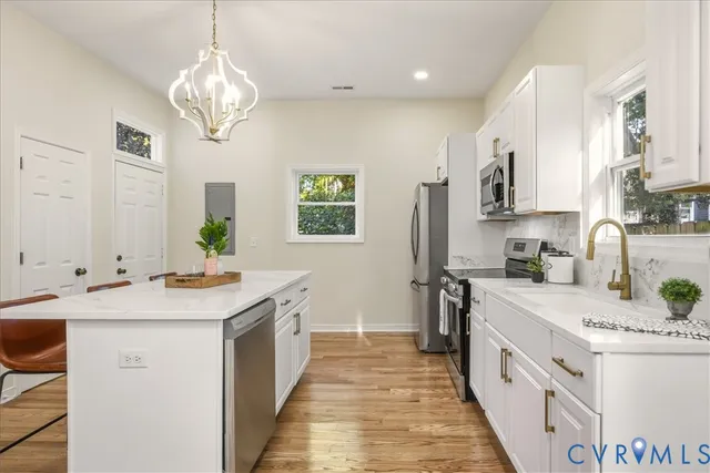 a kitchen with stainless steel appliances a sink a stove and cabinets