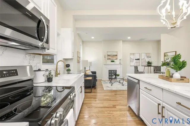 a view of a hallway with wooden floor and a bathroom