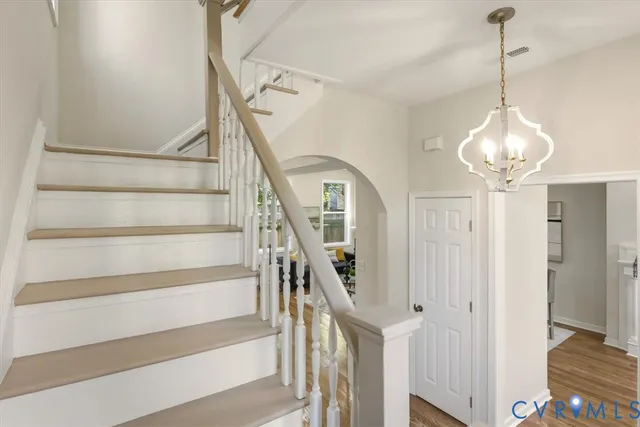 a view of a white house next to a yard with potted plants