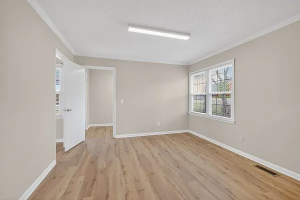 wooden floor in an empty room with a window