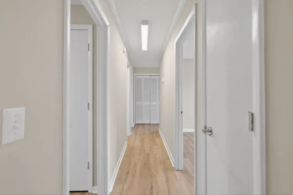 a view of a hallway with wooden floor and staircase