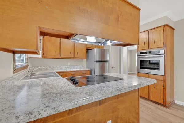 a kitchen with stainless steel appliances granite countertop a sink and a stove