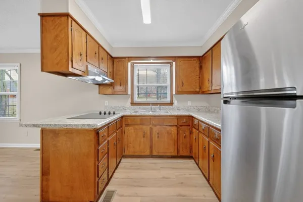 a kitchen with stainless steel appliances granite countertop a sink and a refrigerator