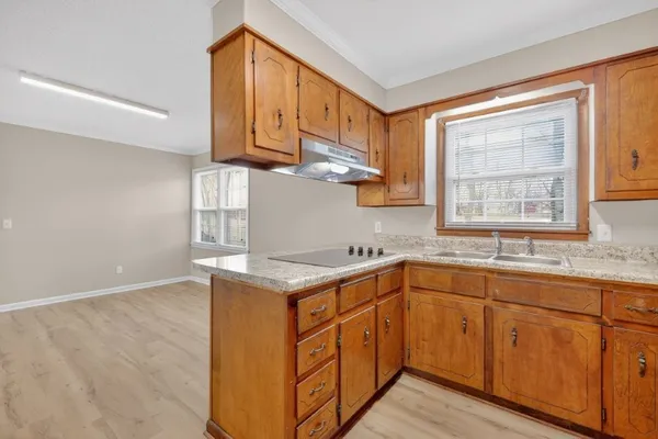 a kitchen with stainless steel appliances granite countertop a sink a stove and cabinets