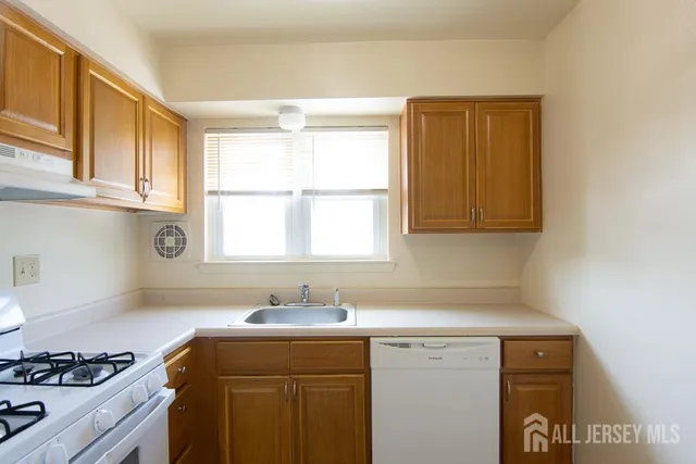a kitchen with a sink cabinets and a window