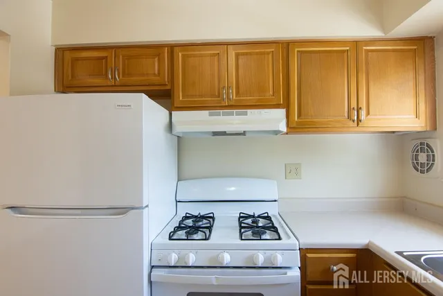 a kitchen with white cabinets and white appliances