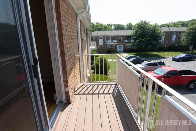 a view of a balcony with wooden floor and fence