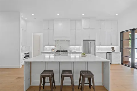 a kitchen with granite countertop white cabinets and chairs