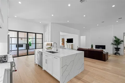 a large white kitchen with a large window