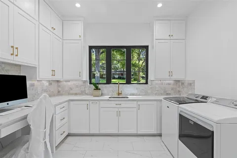 a kitchen with white cabinets appliances and a sink