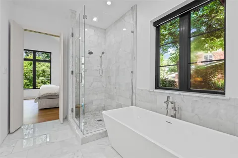 a bathroom with a tub a window and a shower