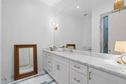 a bathroom with a granite countertop double vanity sink and a mirror