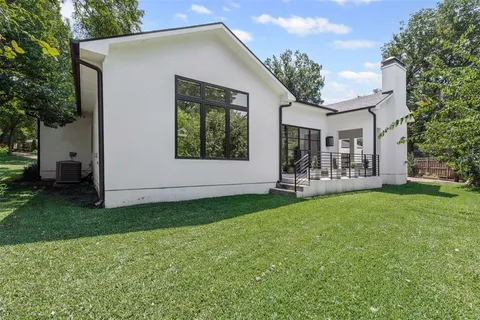 a view of a house with backyard and a tree