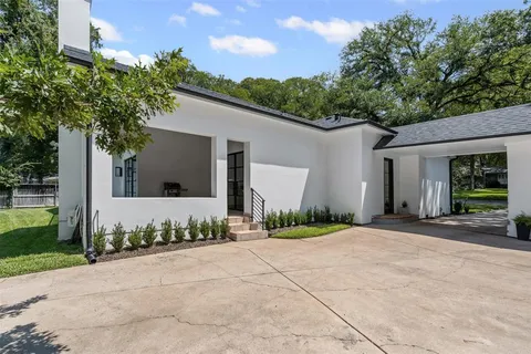 a front view of a house with a yard and potted plants