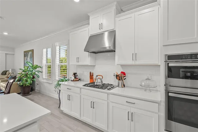 a spacious bathroom with a granite countertop sink a mirror a bathtub and next to a window
