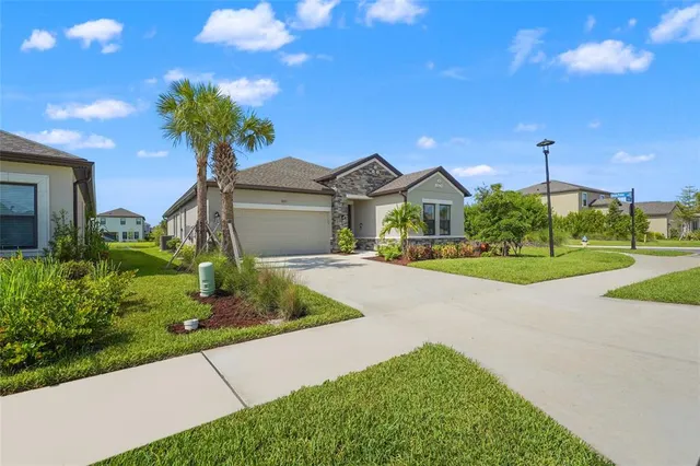 a front view of a house with a yard and potted plants