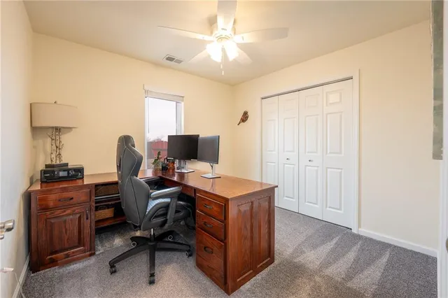 a view of a workspace with furniture and a window