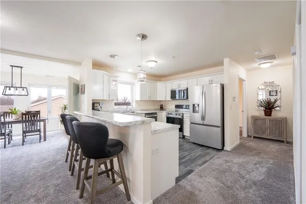 a kitchen with refrigerator and chairs