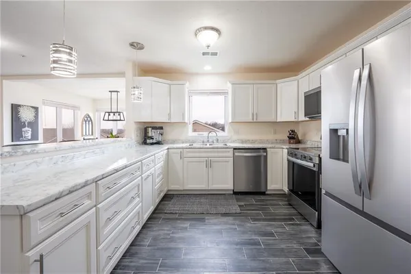a kitchen with granite countertop a sink stainless steel appliances and cabinets