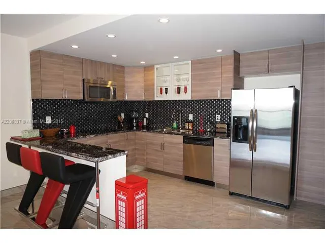 a kitchen with stainless steel appliances granite countertop a refrigerator a stove and a refrigerator