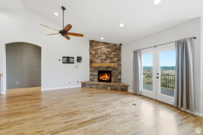 722 West Webb Circle, Unit 2 Draper, UT 84020 - Photo 11 of 39 Vaulted ceiling with a ceiling fan, stone-clad fireplace with a wood mantle, wood-finish flooring, and double patio doors