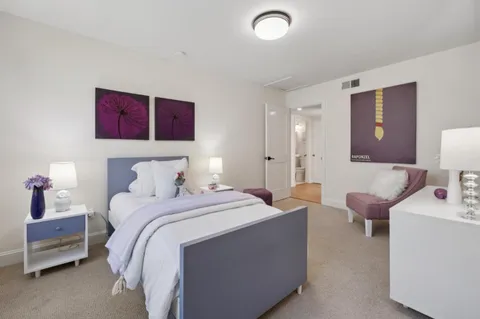 a bedroom with a bed and a large window