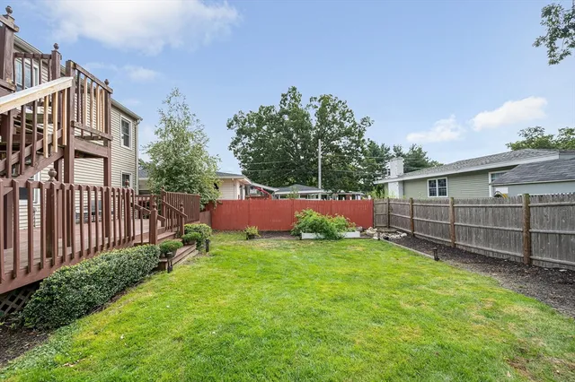 a view of a backyard with a small cabin and wooden fence
