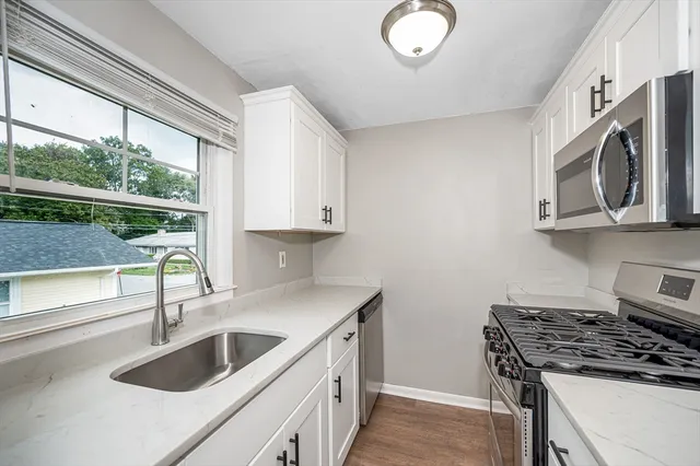 a kitchen with stainless steel appliances granite countertop a sink and a stove