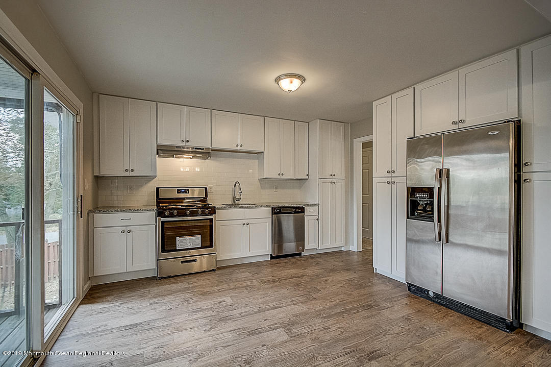 24 Pine Road Howell, NJ 07731 - Photo 6 of 21 a kitchen with a refrigerator stainless steel appliances wooden floor and a window